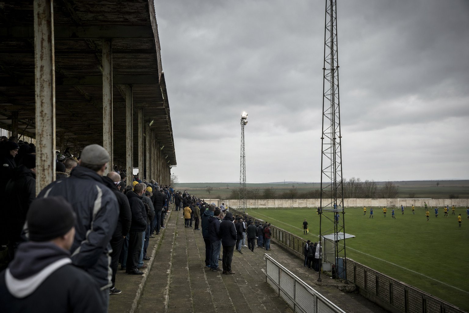 Tribuna cubierta de una cancha de ascenso argentina en una tarde gris